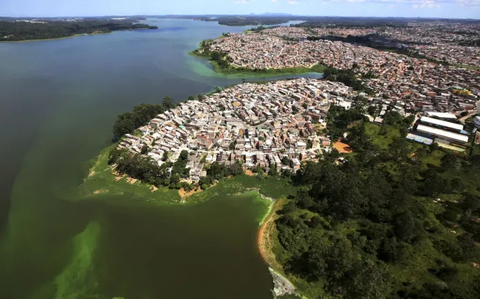 Framed Print : An aerial view of shows illegally built slums on the border of the polluted water of Framed Print : An aerial view of shows illegally built slums on the border of the polluted water of