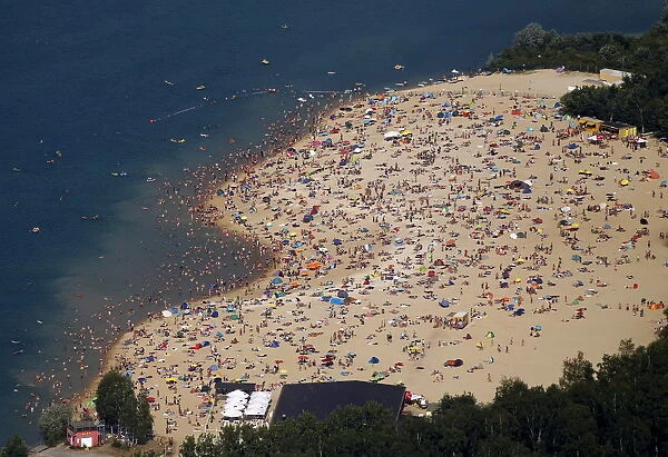 An aerial view shows people at a beach on the shores of the Silbersee lake on a hot