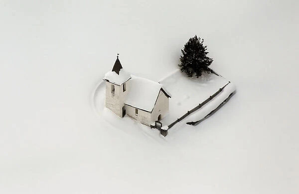 An aerial view shows the snow covered church of the village of Jenisberg near Davos