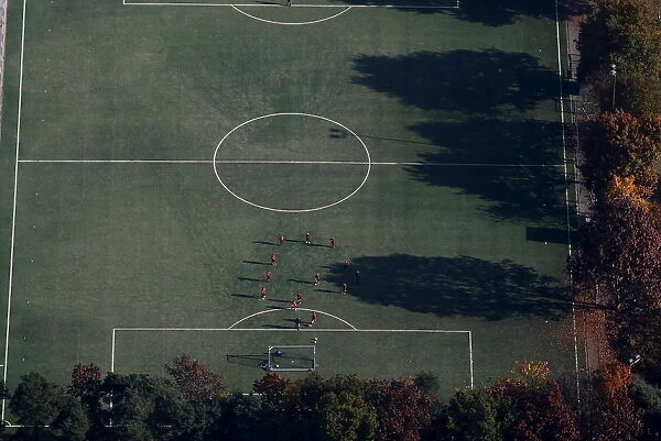 An aerial view shows soccer players standing on a field on a sunny autumn day in
