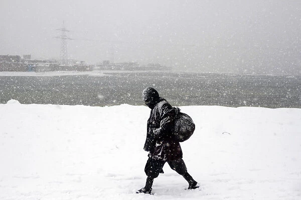 An Afghan man walks during a snowy day in Kabul