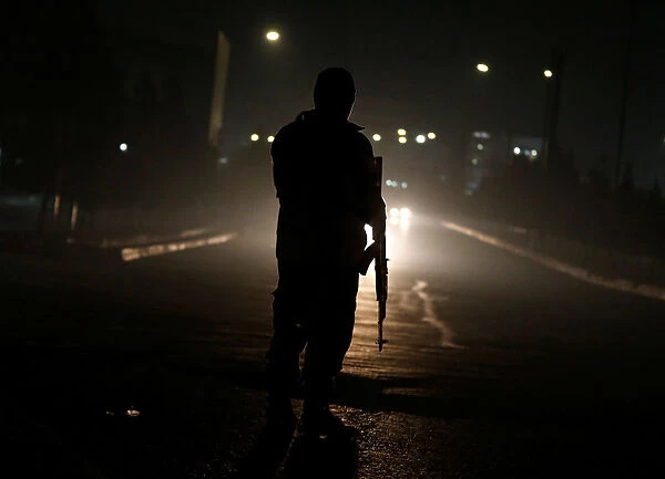 An Afghan policeman keeps watch near the site of an attack on the Intercontinental Hotel