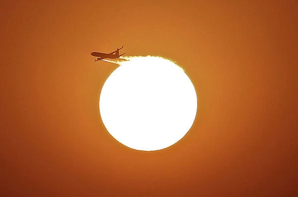 An aircraft files near the setting sun in New Delhi