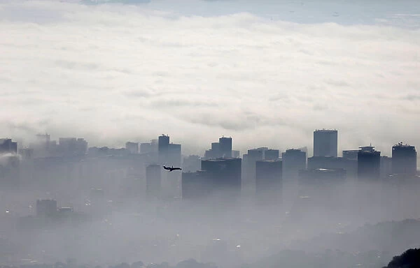 An airplane flies over buildings in Rio de Janeiro