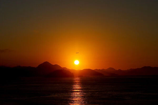 Airplane is seen in the sky during sunrise in Rio de Janeiro