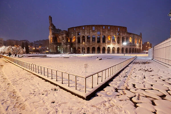 The ancient Colosseum is seen during a heavy snowfall early in the morning in Rome