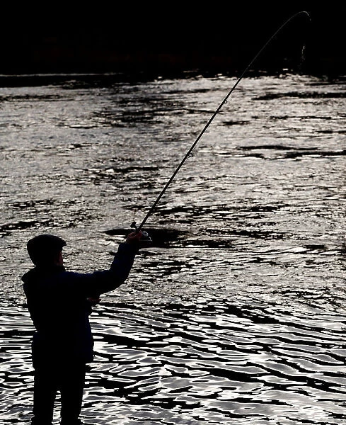 An angler casts his line on the opening day of the salmon fishing season on the River Tay