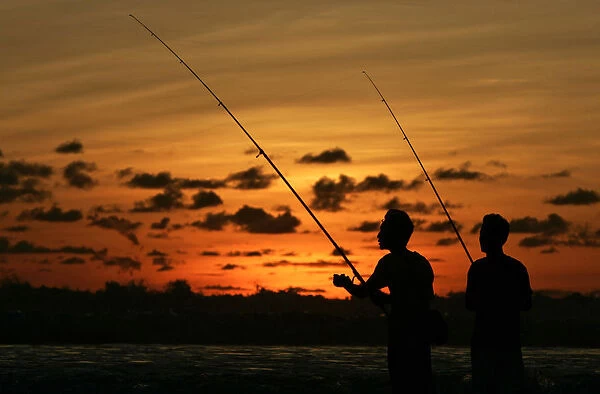 Anglers fish off Legian beach on the Indonesian resort island of Bali