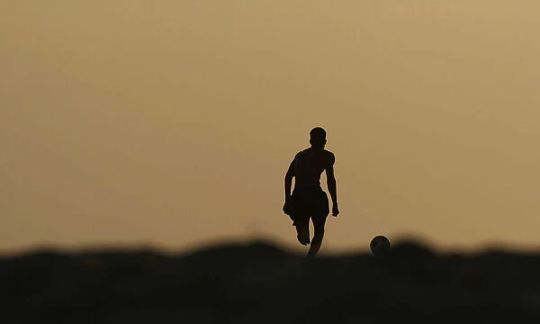 Angolan youths play soccer on the beach in the capital Luanda