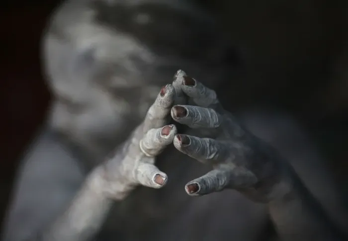 Framed Print : Ash-encrusted hands of a sadhu are seen as he sits beside a fire after applying ashes to his face Framed Print : Ash-encrusted hands of a sadhu are seen as he sits beside a fire after applying ashes to his face