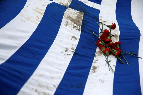 Athens Polytechnic school students carry a blood-stained Greek flag during a rally