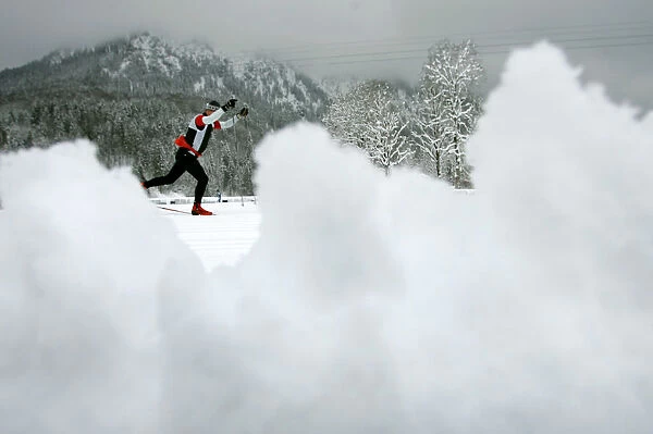 An athlete tries to make his way after heavy snow falls at the cross country race track for the