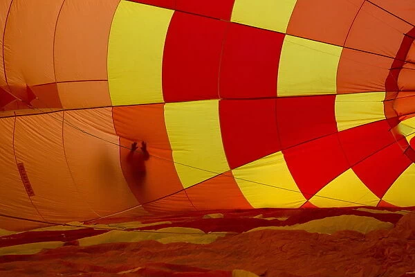 An attendee touches the outside of an inflating hot air balloon during the 2015