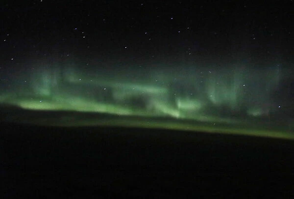 The Aurora Borealis is visible from a plane at 37, 000 feet above the Labrador Sea