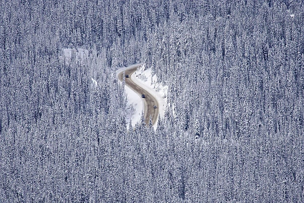 Automobiles makes their way along a mountain road during winter in Lake Louise