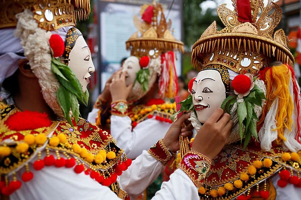 Balinese Hindus wear masks as they prepare before performing sacred Telek dance at