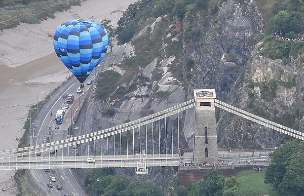 A balloon flies near the Clifton Suspension Bridge during a mass take off at the annual