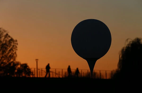 A balloon is silhouetted at sunset near the Spree river in Berlin
