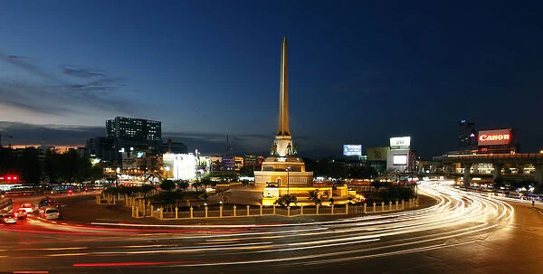 Bangkoks Victory Monument is seen lit as cars go past its roundabout