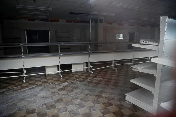 Bare shelves are seen inside a closed down retail unit in Stockport, near Manchester