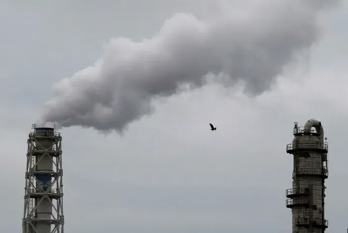 Framed Print : A bird flies near smoke being emitted from cement factory in an industrial area of Framed Print : A bird flies near smoke being emitted from cement factory in an industrial area of