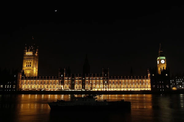 A boat is moored on the Thames across from the Houses of Parliament and Big Ben in London