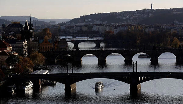 A boat passes under a bridge in central Prague
