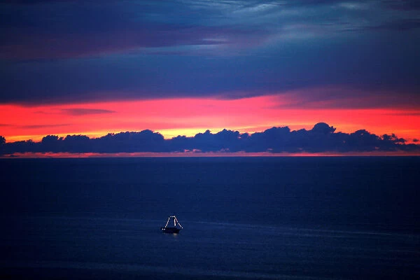 A boat sails during the sunset in the sea of Fortaleza