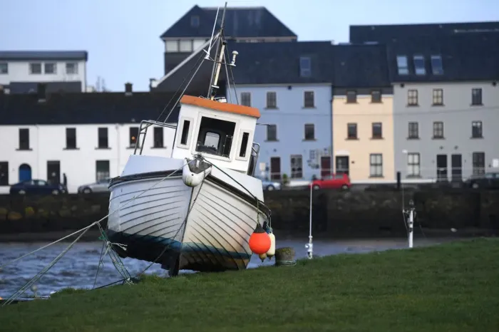 Framed Print : A boat is stranded on the edge of a pier after it was washed there by floods in Galway