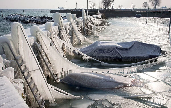 Boats are covered with a thick layer of ice at Lake Constance in the port of Romanshorn