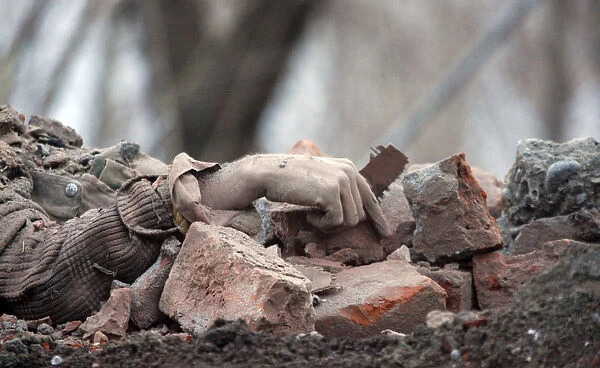 The body of a suspected militant lies amongst rubble after a gun battle with the Indian