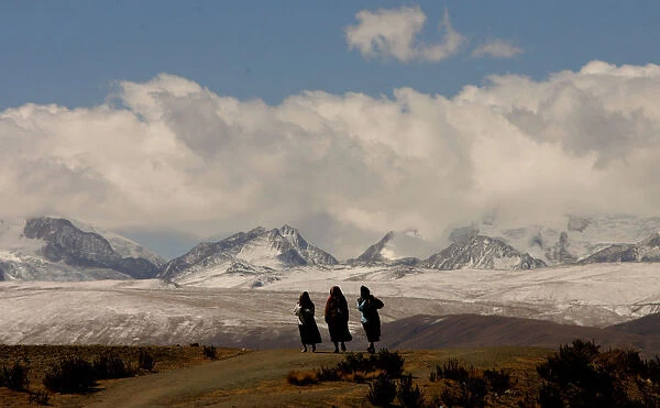 BOLIVIAN WOMEN AYMARAS WALK ON HIGHWAY BY ILLAMPU MOUNTAIN RANGE