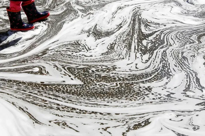 Framed Print : The boots of a young girl are seen in a puddle caused by melted snow at Madison Square