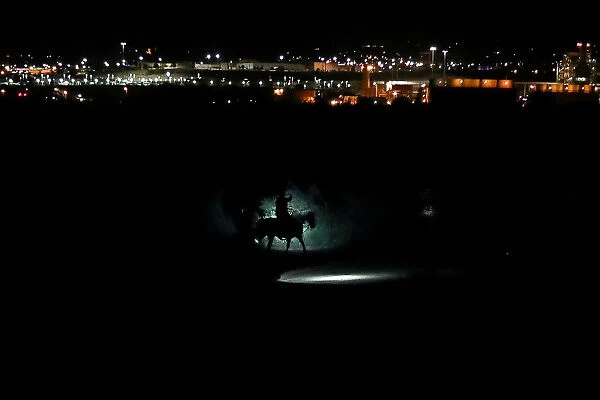 Border Patrol agents on horses track a man along the Rio Grande River after he illegally
