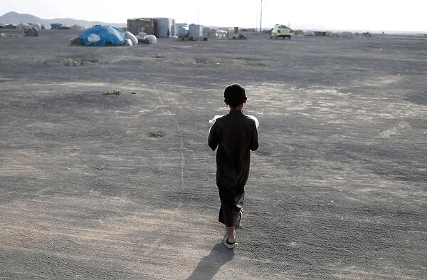 A boy, displaced from fighting in the Islamic State stronghold of Raqqa walks in desert