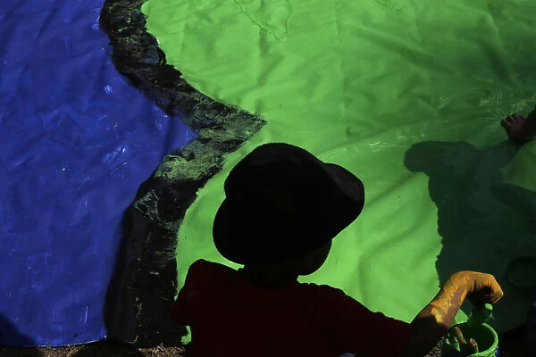 A boy paints during a Guinness World Record event as part of celebrations for the