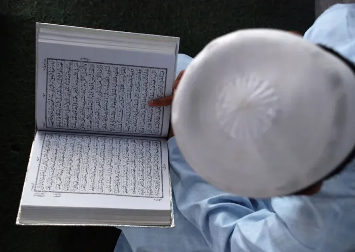 Framed Print : A boy reads the Koran in Mathura