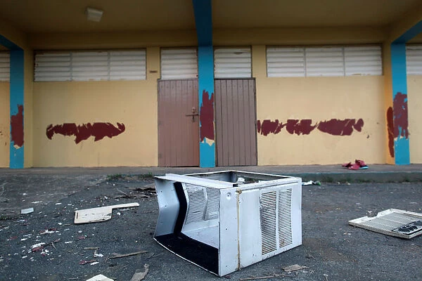 A broken air conditioner is seen outside a shut-down elementary school, in Toa Baja