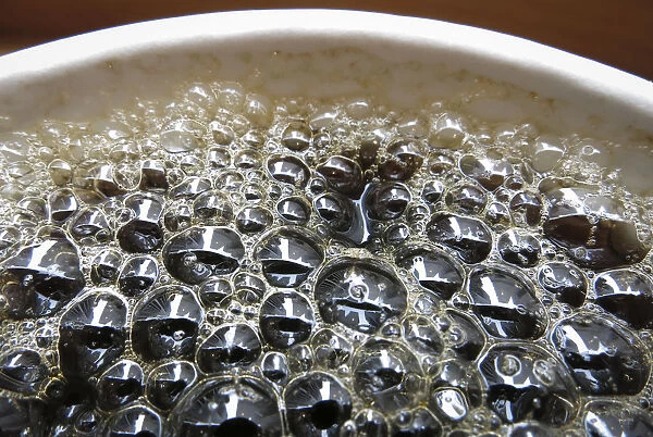 Bubbles form on the surface of a cup of coffee in a cafe in New York