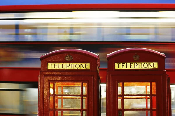 A bus passes traditional telephone boxes in London