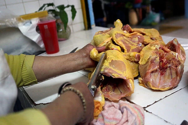 Butcher cuts chicken at a market stall in Mexico City