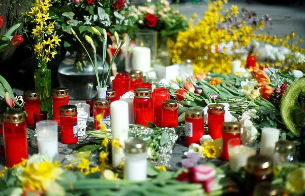 Candles and flowers are placed at the site where, on April 7