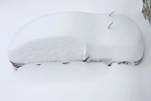 A car is buried in snow from an overnight snowstorm inside Washington DC Beltway in