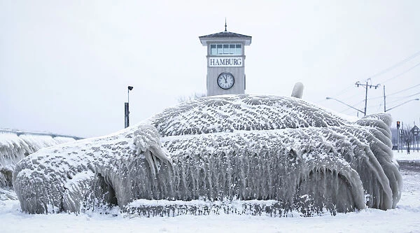 A car covered with ice remains stranded on the waterfront in Hamburg, New York