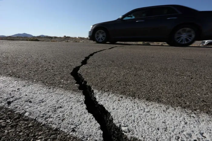 Framed Print : A car passes over a fissure that opened on a highway during a powerful earthquake that Framed Print : A car passes over a fissure that opened on a highway during a powerful earthquake that