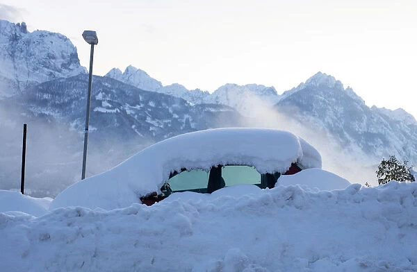 Car is seen covered with snow in village of Iselsberg