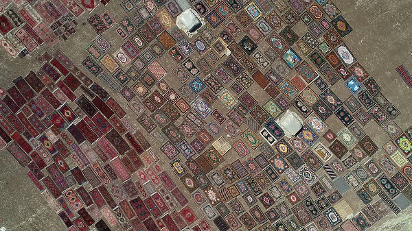 Carpets are laid out in fields to soften their colors under sizzling sun in Dosemealti