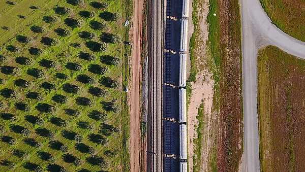 Carriages of a train are loaded with grain at a storage site on the outskirts of the