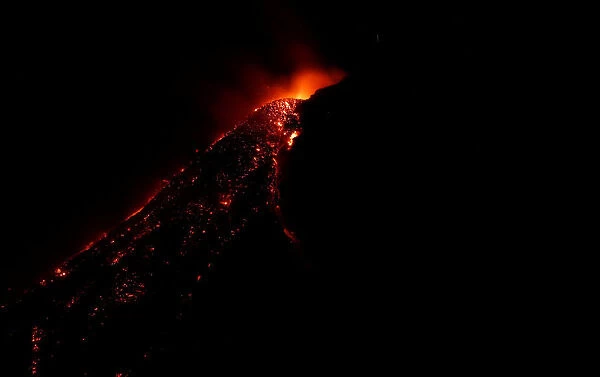 Cascading lava flows down the slope of Mayon Volcano during a total lunar eclipse in