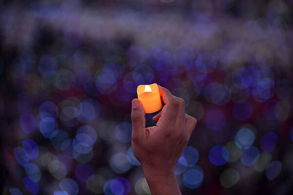 Catholic faithful hold up LED candles as Pope Francis attends a meeting with Filipino